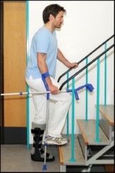 Person stående på bandageret ben ved trappe støtter på albuestok og løfter rask ben op på trin