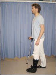 Gående person flytter bandageret ben og stok i modsat arm frem