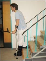 Person på trappe sætter albuestok og bandageret ben et trin ned