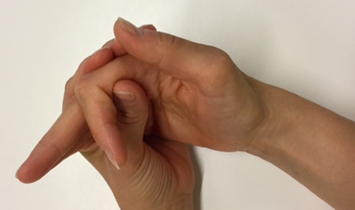 Billede af 2 hænder. Den ene hånd holder lige overfor mellemleddet på pegefingeren. Pegefingeren bøjer i mellemleddet