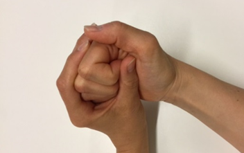 Hånd, hvor fingrene bøjes ved hjælp af den anden hånd