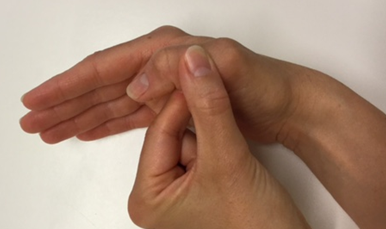 Billede af hånd, hvor tommelfingeren bøjer i det yderste led, mens den anden hånd holder omkring tommelfingeren