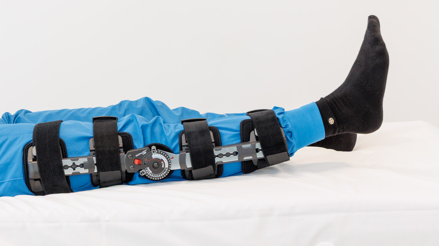 person med hængselbandage løfter hælene