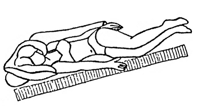 Person ligger under lag der hælder 30 grader ned ved hovedgærde. Personen ligger med overkrop halvt på siden og halvt på ryggen