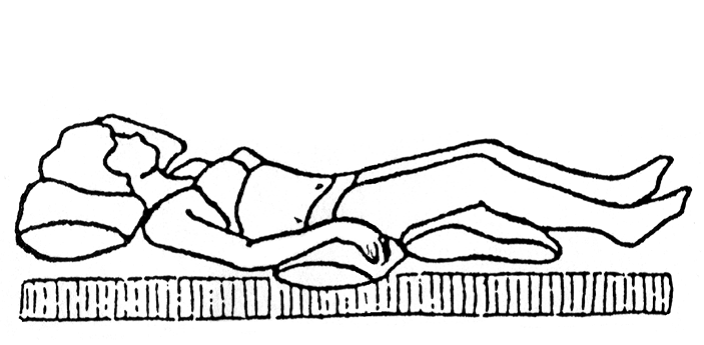 Person ligger på ryggen med puder under knæ og hoved