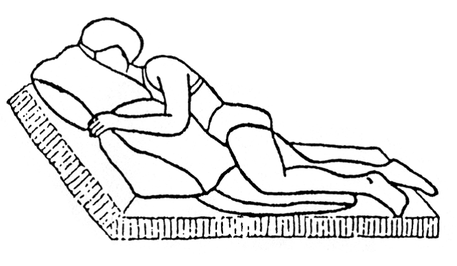Person ligger på skrådt på siden/maven opad 30 grader løftet hovedgærde