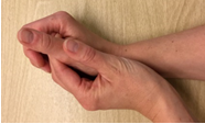En hånd holder om den anden strakte tommelfinger mens håndleddet er bagud bøjet håndkantstilling.png