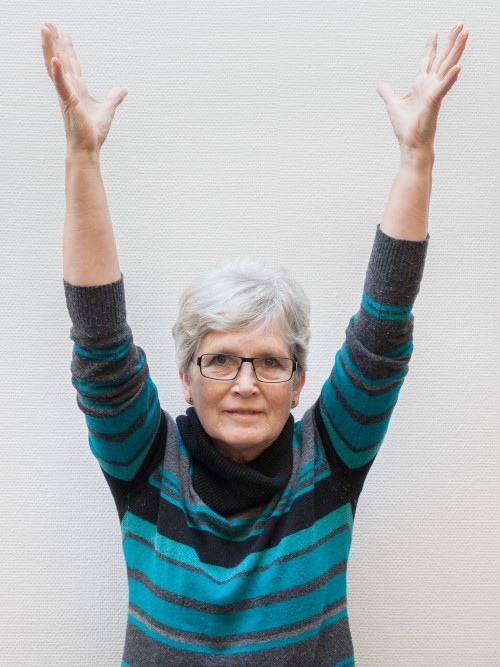 Kvinde st&aring; med armene strakte over hovedet