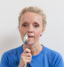 Kvinde presser tunge mod spiseske