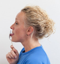 Kvinde presser tunge ligefrem mod spiseske 