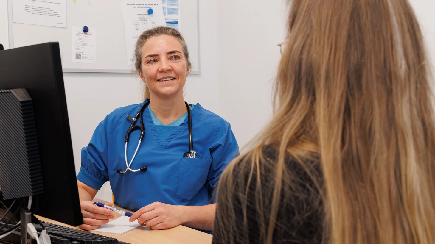 Patient og læge taler sammen ved bord