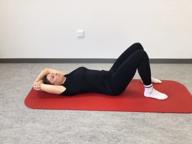 Kvinde ligger på gulvet med hænder over hovedet