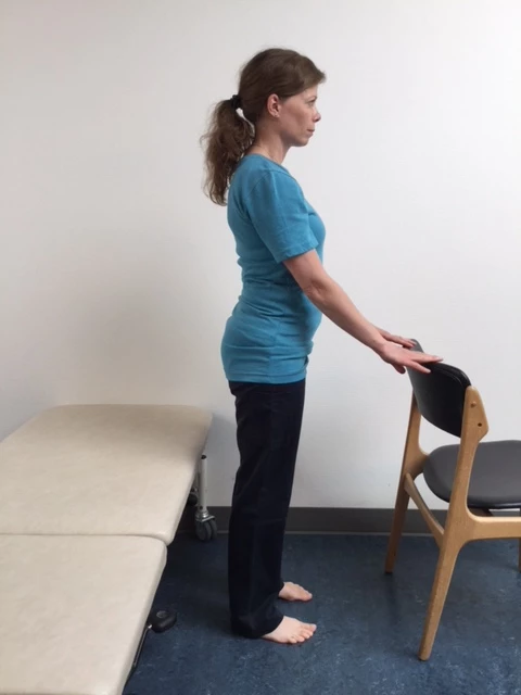 Kvinde står ved stol