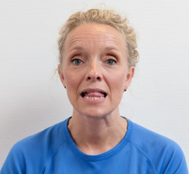 Kvinde holder tungen mellem tænderne