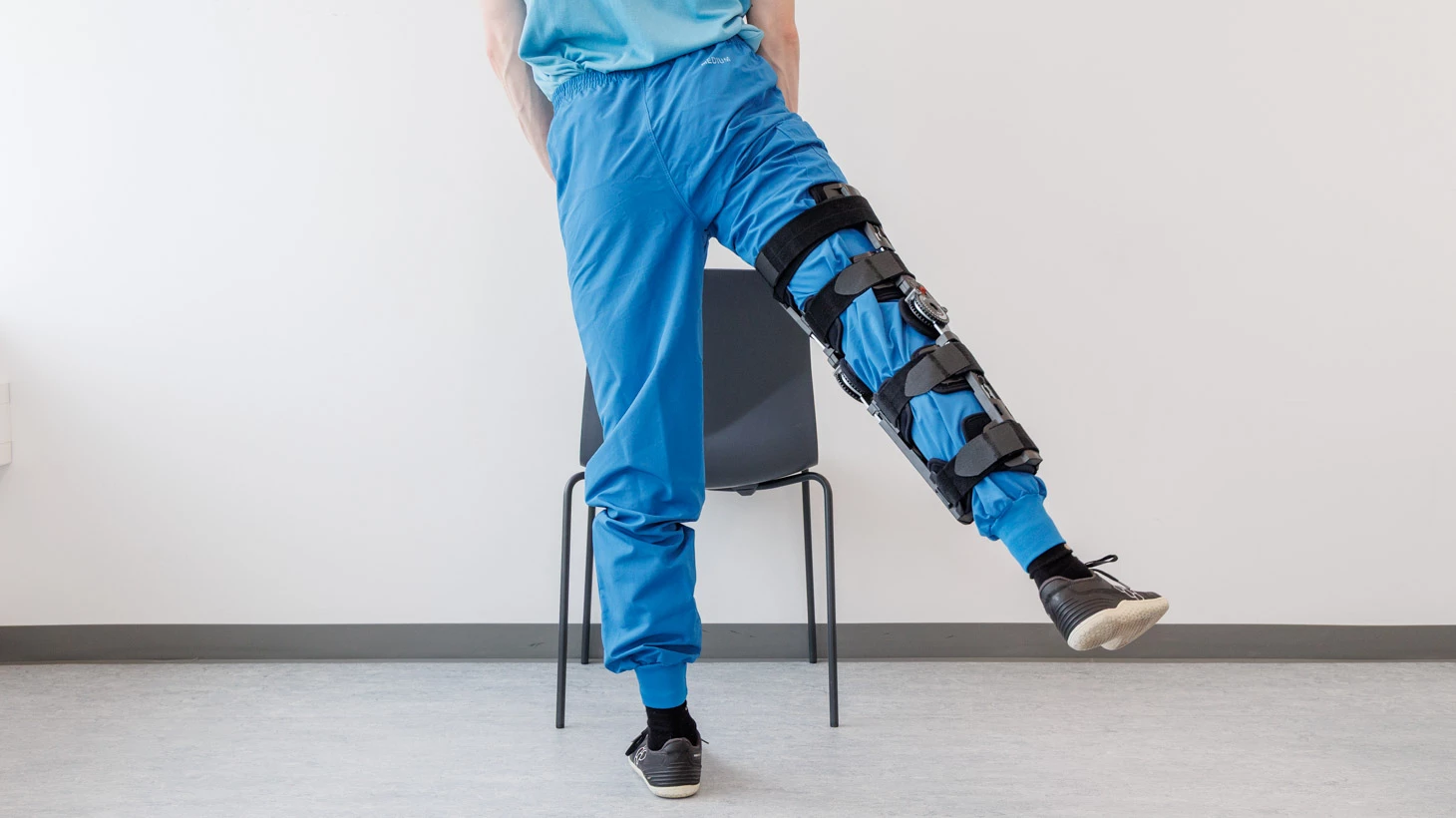 Person med hængselbandage fører benet bagud