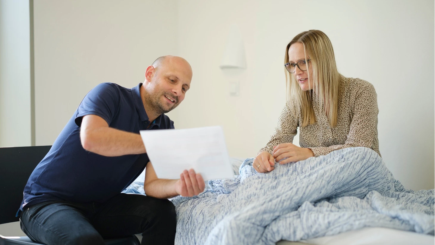 Billede af medarbejder og patient, der sammen kigger på et stykke papir