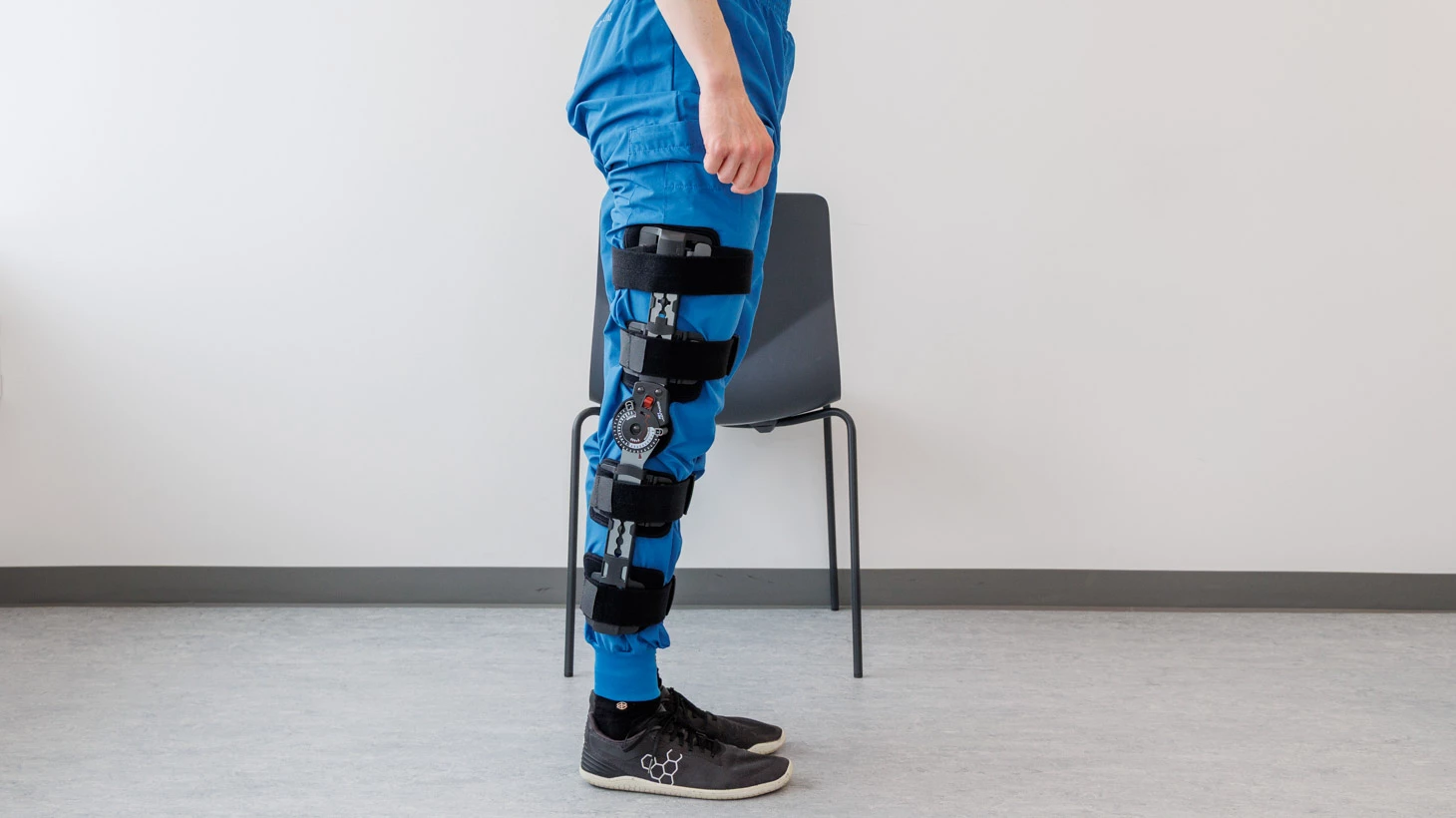 Person står og støtter sig til stol