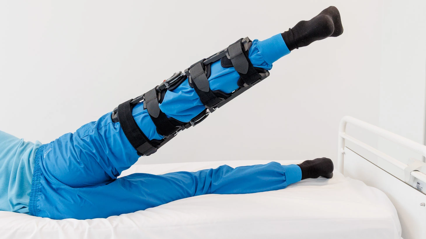 Person med hængselbandage løfter benet bagud